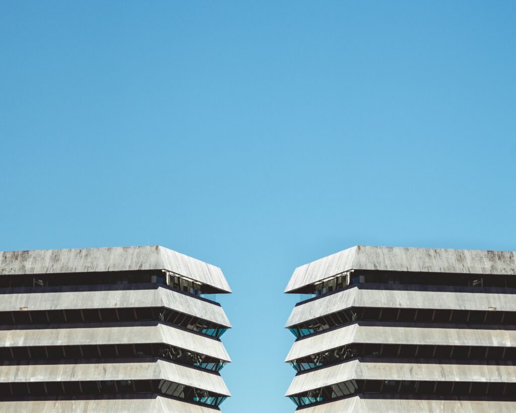 Office buildings with glass and concrete facades beneath a blue sky